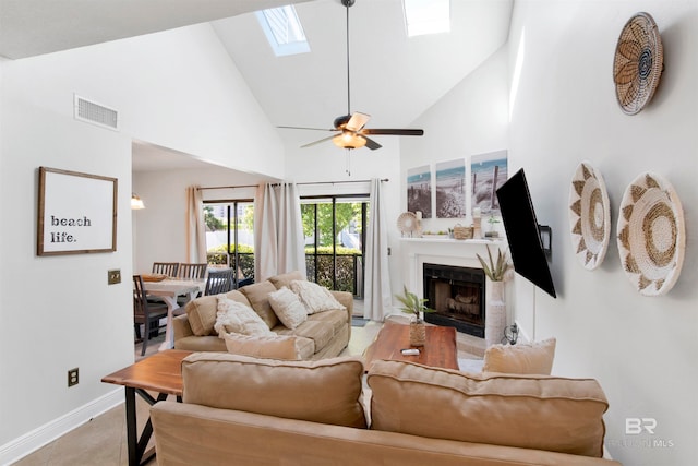 living room featuring high vaulted ceiling, ceiling fan, and a skylight