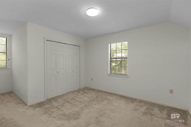 143 Kingswood Dr, Daphne, AL 36526 - unfurnished bedroom featuring multiple windows, light colored carpet, a closet, and lofted ceiling