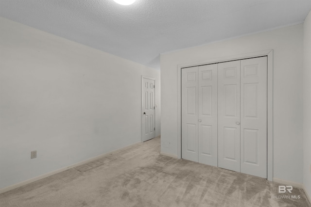 143 Kingswood Dr, Daphne, AL 36526 - unfurnished bedroom with carpet floors, a closet, and a textured ceiling