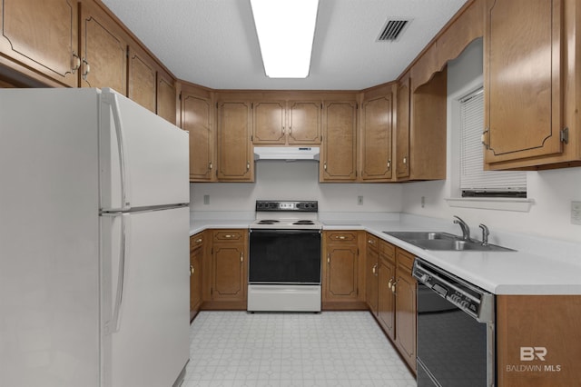 143 Kingswood Dr, Daphne, AL 36526 - kitchen with white appliances, under cabinet range hood, light floors, and brown cabinets