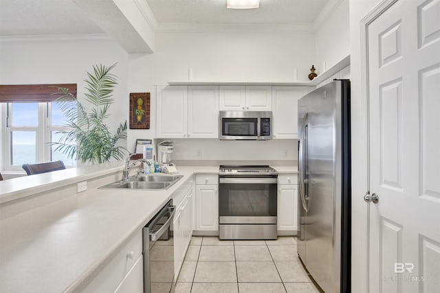 kitchen featuring white cabinets, crown molding, sink, light tile patterned flooring, and stainless steel appliances