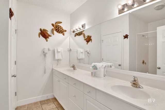 bathroom with tile patterned flooring, vanity, and a textured ceiling