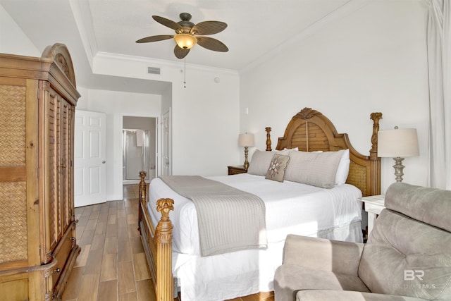 bedroom featuring hardwood / wood-style floors, ceiling fan, and ornamental molding