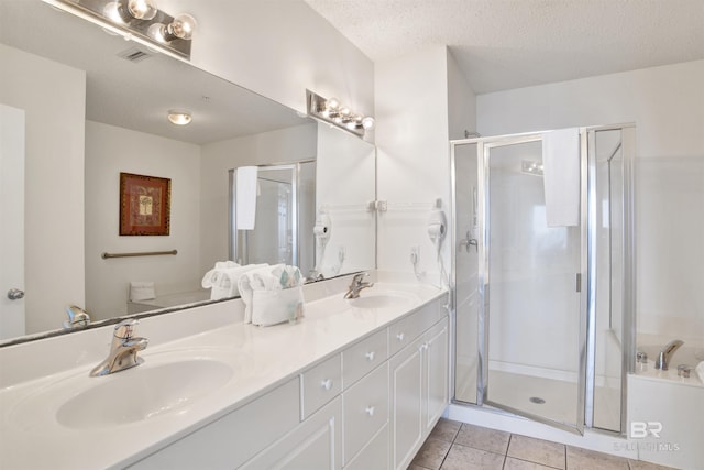 bathroom with tile patterned flooring, vanity, a textured ceiling, and an enclosed shower