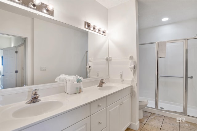 bathroom with vanity, tile patterned floors, toilet, a textured ceiling, and a shower with shower door