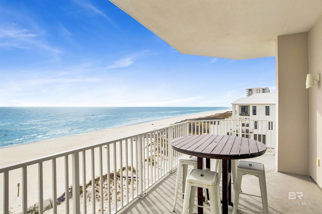 balcony featuring a view of the beach and a water view