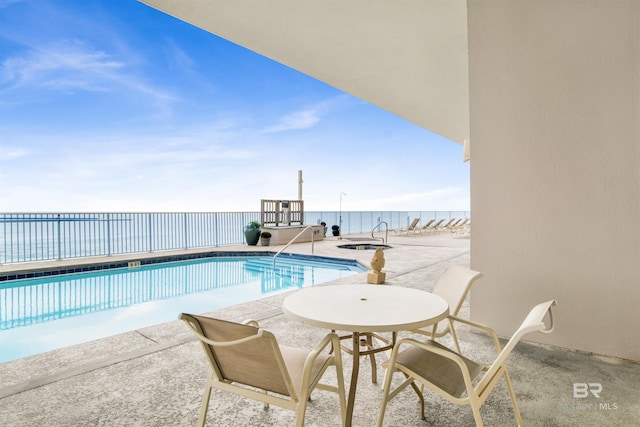 view of swimming pool featuring a patio area and a water view