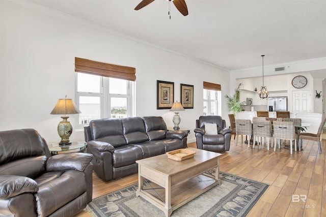 living room featuring light hardwood / wood-style floors, a wealth of natural light, and ornamental molding