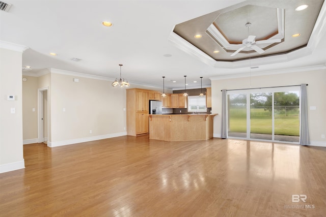 unfurnished living room with a ceiling fan, a chandelier, light wood-style flooring, ornamental molding, and baseboards