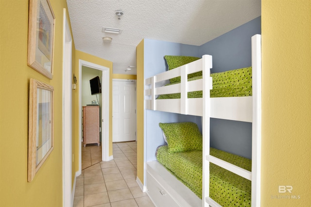 unfurnished bedroom featuring light tile patterned floors and a textured ceiling