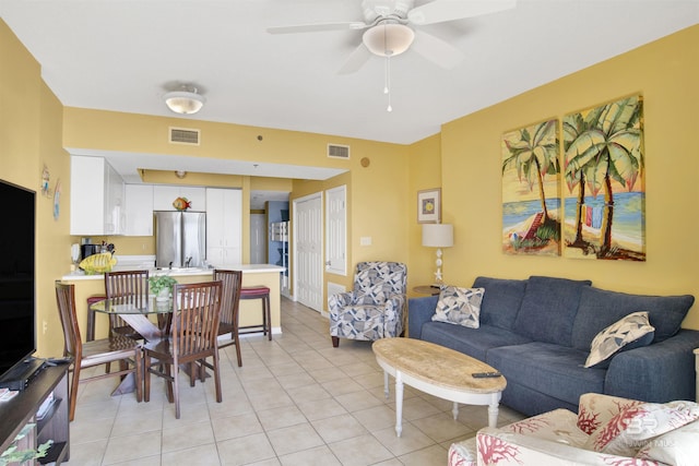 living room with ceiling fan and light tile patterned floors