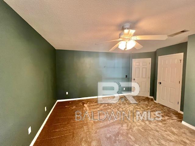 bathroom with ceiling fan and a textured ceiling