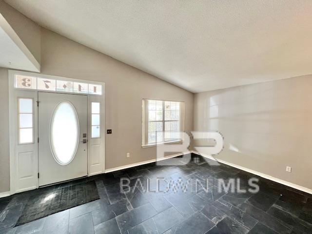 entrance foyer featuring vaulted ceiling and a textured ceiling