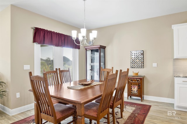 dining area featuring light hardwood / wood-style flooring and an inviting chandelier