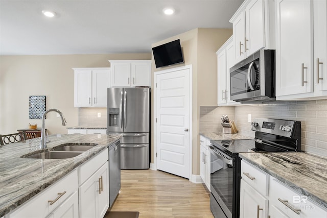 kitchen with white cabinets, light wood-type flooring, sink, and appliances with stainless steel finishes