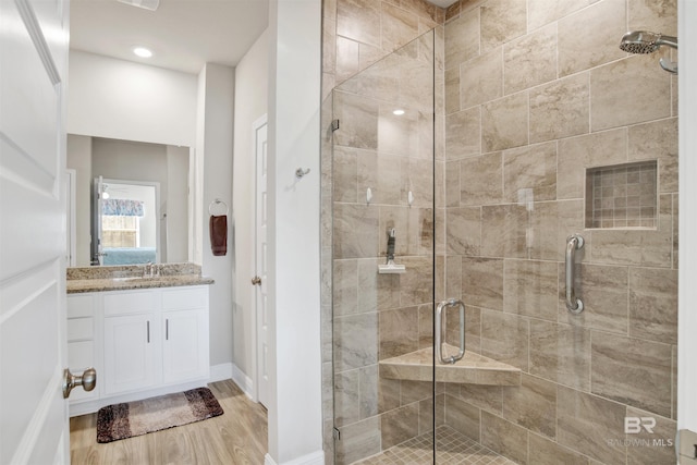 bathroom featuring hardwood / wood-style floors, vanity, and an enclosed shower