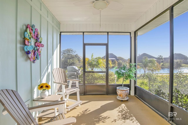 sunroom / solarium featuring ceiling fan and a water and mountain view