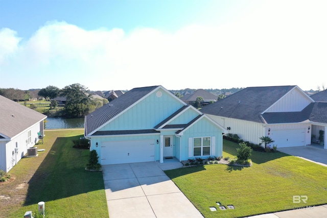 view of front of house featuring a front yard, central AC, a water view, and a garage