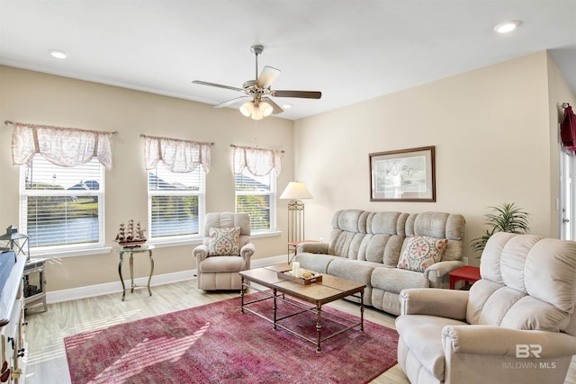 living room featuring ceiling fan, light hardwood / wood-style flooring, and a healthy amount of sunlight