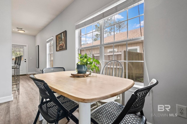 dining area featuring light wood finished floors and baseboards