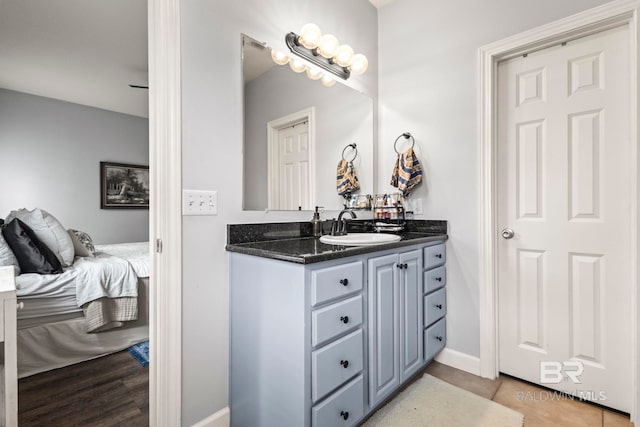 bathroom featuring baseboards, connected bathroom, and vanity