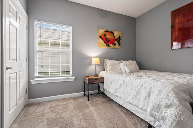 bedroom featuring light colored carpet and baseboards