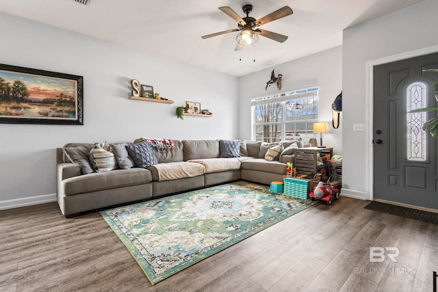 living area with ceiling fan, baseboards, and wood finished floors