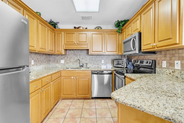 kitchen with a sink, stainless steel appliances, tasteful backsplash, light tile patterned flooring, and visible vents