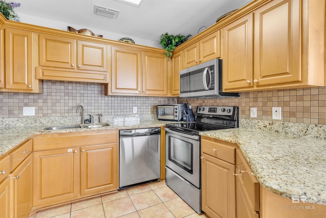 kitchen featuring a sink, tasteful backsplash, visible vents, light tile patterned floors, and appliances with stainless steel finishes