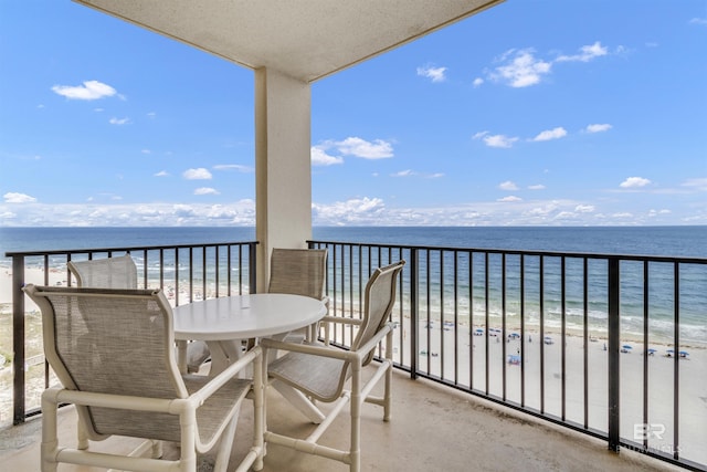 balcony with a water view and a view of the beach