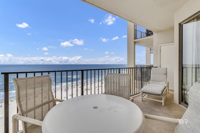 balcony featuring a beach view and a water view