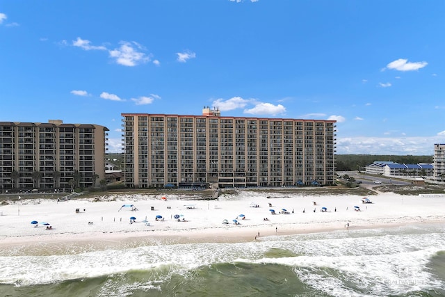 view of building exterior with a water view and a view of the beach