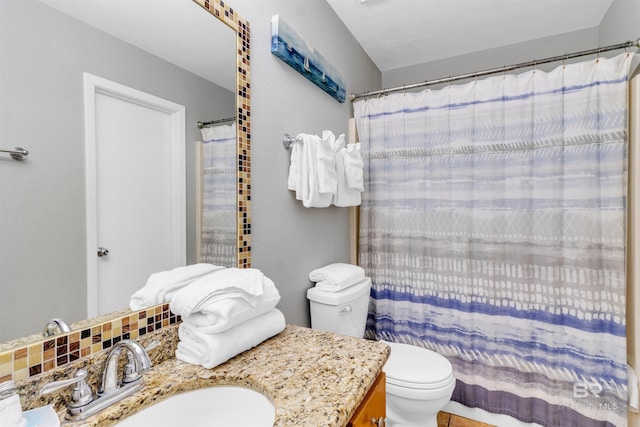 bathroom featuring toilet, curtained shower, and vanity