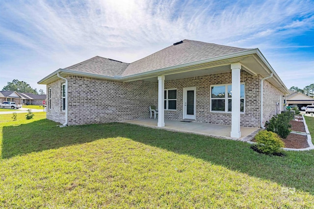 rear view of house with a lawn and a patio area