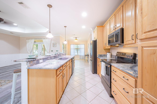 kitchen with sink, hanging light fixtures, light stone counters, stainless steel appliances, and crown molding