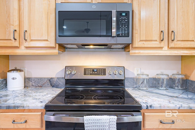 kitchen featuring appliances with stainless steel finishes, light stone counters, and light brown cabinetry