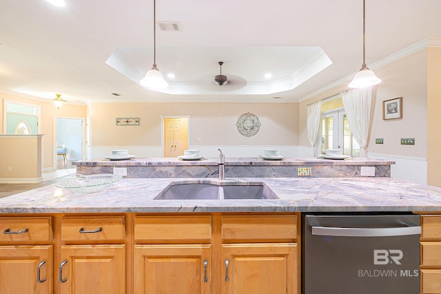 kitchen with sink, a kitchen island with sink, ornamental molding, stainless steel dishwasher, and a raised ceiling