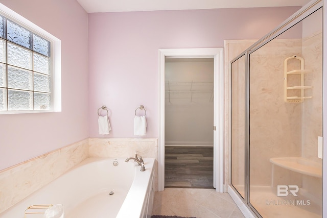 bathroom with tile patterned flooring and separate shower and tub