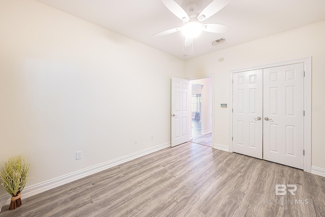 unfurnished bedroom with ceiling fan, a closet, and light wood-type flooring