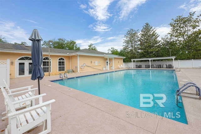 view of swimming pool with a patio area and french doors