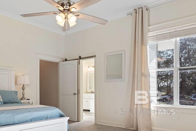 bedroom with multiple windows, ceiling fan, ensuite bath, and a barn door