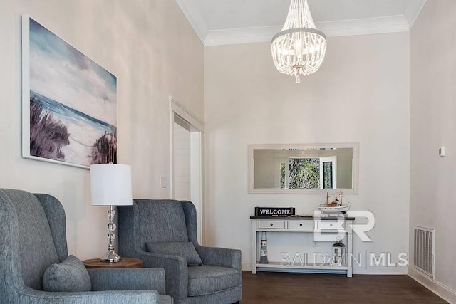 living area featuring dark hardwood / wood-style flooring, a chandelier, and ornamental molding