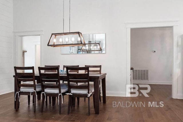 dining space with a high ceiling and dark hardwood / wood-style floors