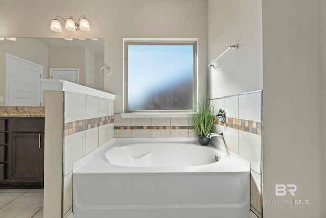 bathroom with a washtub, vanity, and tile patterned flooring