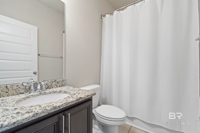 bathroom with toilet, vanity, and tile patterned floors