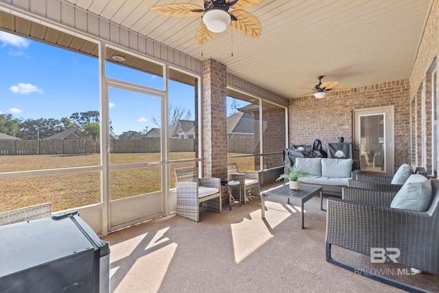 unfurnished sunroom featuring ceiling fan