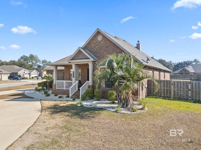 view of front of property with covered porch and a front yard