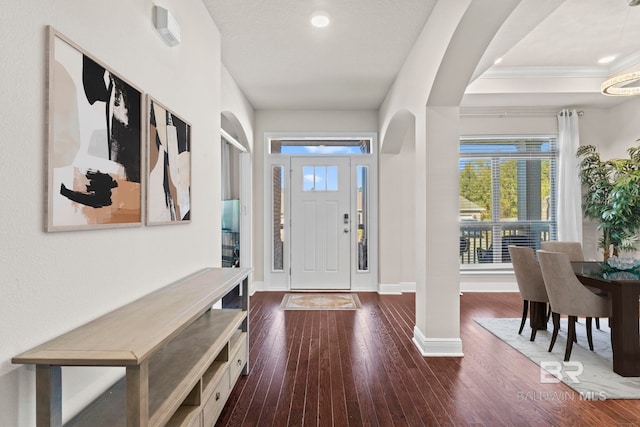 entrance foyer featuring dark wood-type flooring and ornamental molding