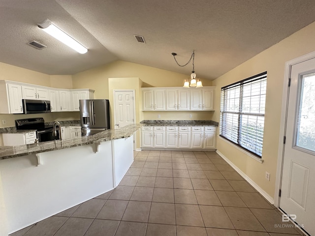 kitchen featuring appliances with stainless steel finishes, a breakfast bar, pendant lighting, white cabinetry, and tile patterned floors