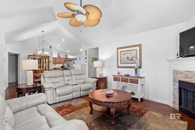 living room with ceiling fan, a stone fireplace, lofted ceiling, and dark hardwood / wood-style floors